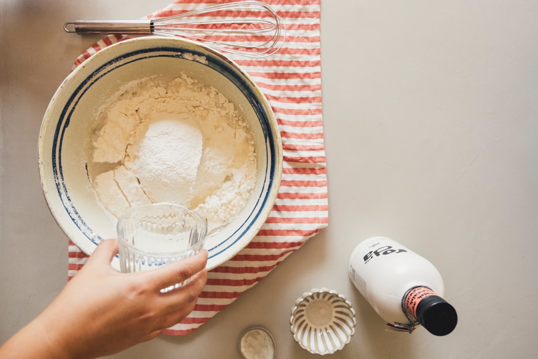 hand-pouring-water-into-flour-in-a-bowl-vtprsjc-bdw